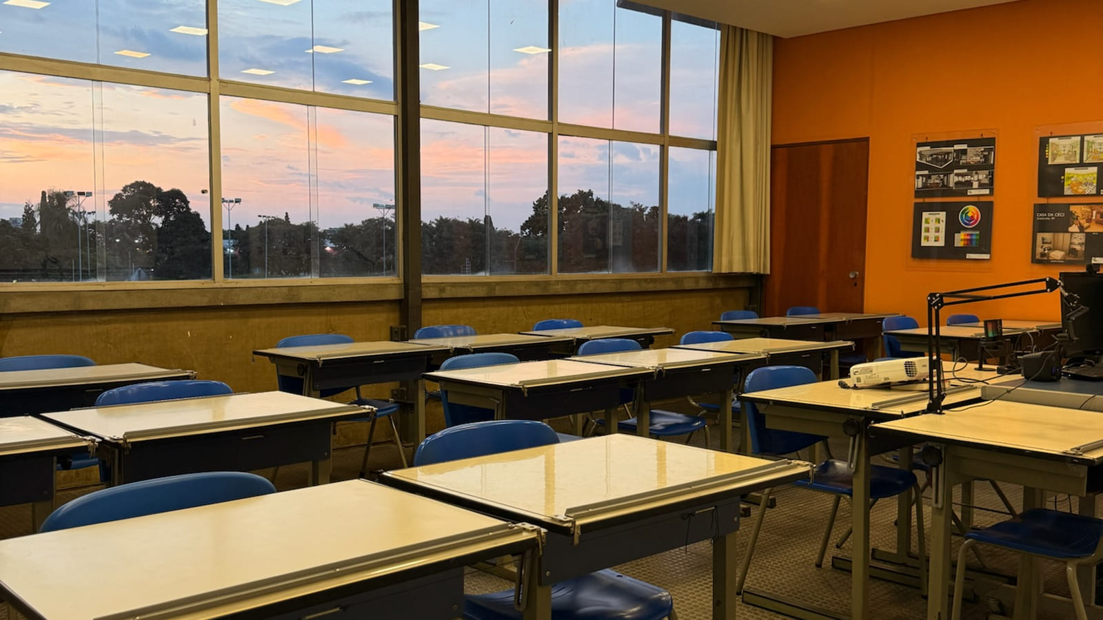 Card 05 – Sala de aula com vista externa ao pôr do sol